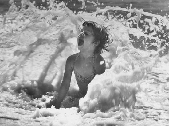 Exuberant Young Girl Getting Splashed by a Wave in the Surf at Jones Beach